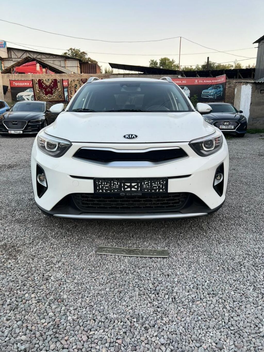 Компактный кроссовер Kia Stonic белого цвета, оснащенный рейлингами на