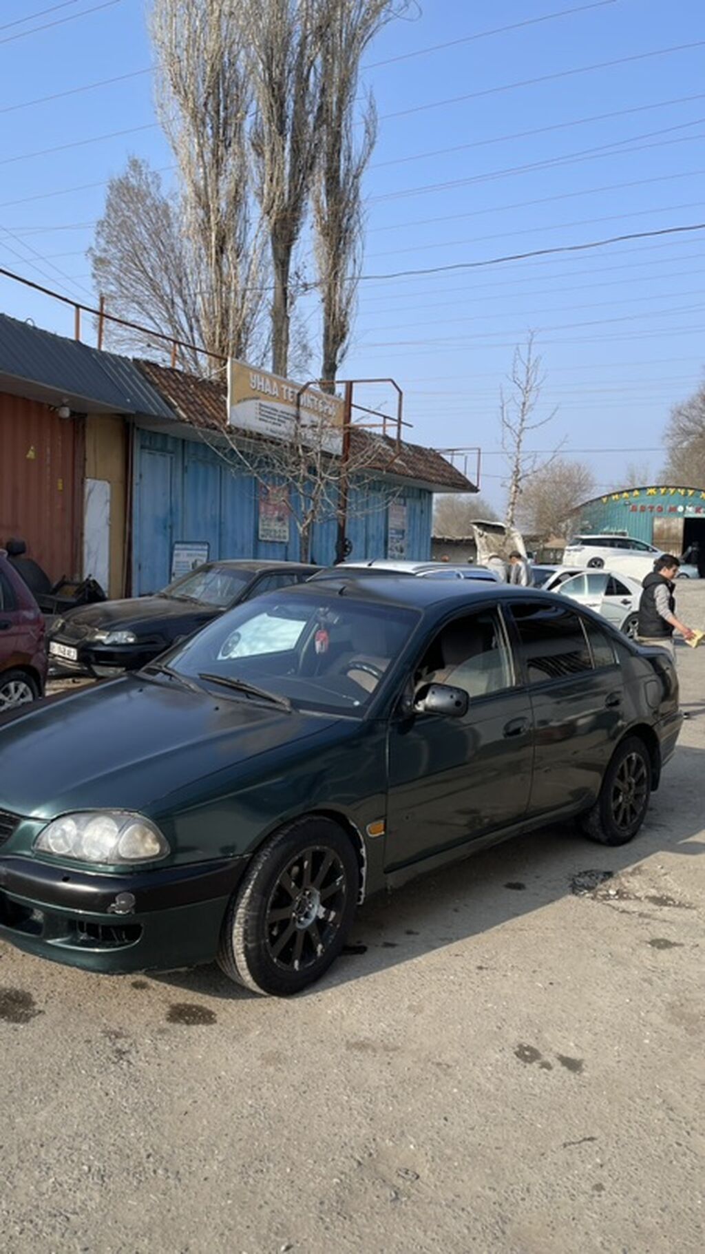 Седан темно‑зеленого цвета. Кузов 4‑дверный, обвес с передним