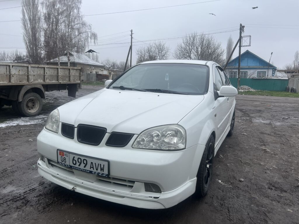 Белый седан компакт-класса. Пятидверный кузов с аэродинамическим