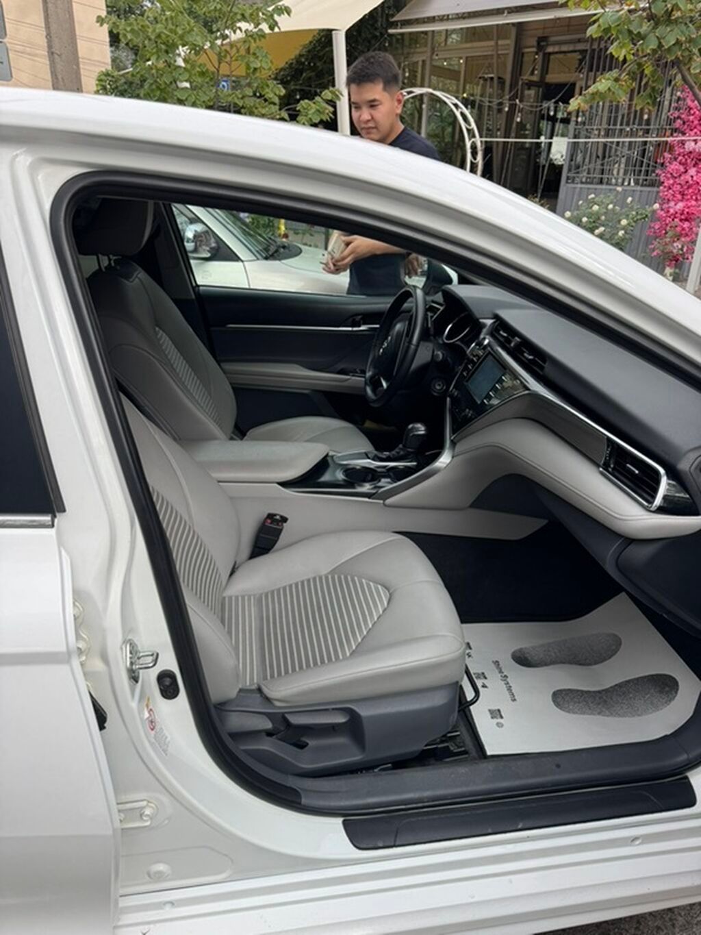 Белый седан с просторным салоном, отделанным светлой кожей и тканью. В